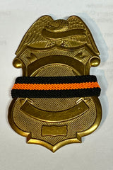 The Stop Gun Violence Wear Orange Awareness / Thin Orange Line Mourning Bands with a thin orange line mourning band 1/2". Band reverses to an all-black mourning band. Public safety officers are wearing thin orange line badge shrouds to raise awareness of gun violence in the community and among police officers, firefighters, Emergency Medical Services and others. Join us in the champagne to Stop Gun Violence. Badges not included.